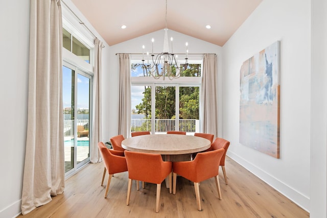 dining space with a healthy amount of sunlight, lofted ceiling, and light wood-type flooring