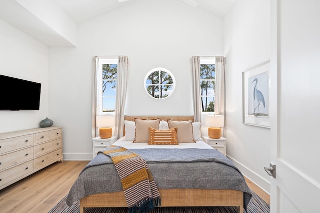 bedroom featuring light hardwood / wood-style floors, high vaulted ceiling, and multiple windows