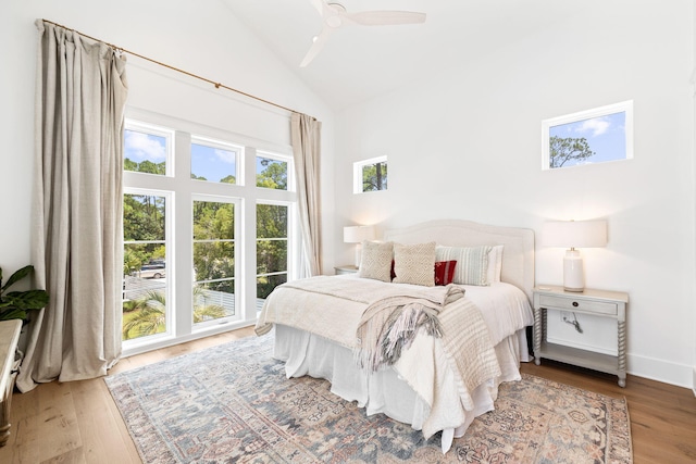 bedroom with access to outside, ceiling fan, high vaulted ceiling, and wood-type flooring