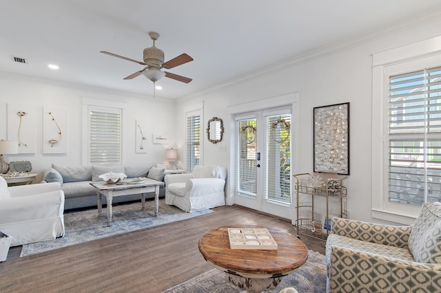 living room featuring wood-type flooring, ceiling fan, and crown molding