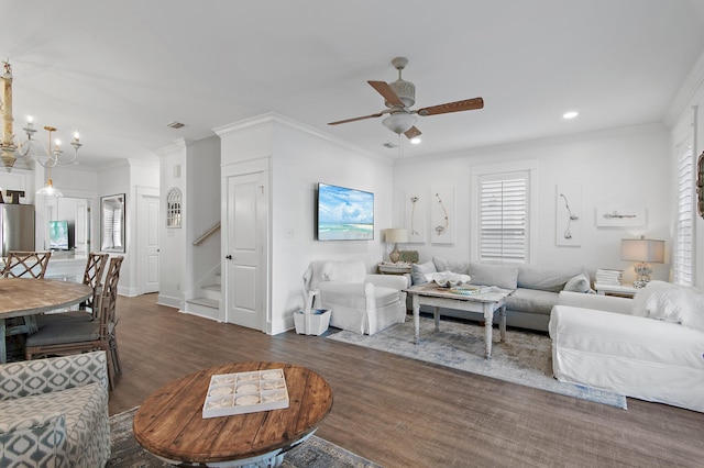 living room featuring ceiling fan with notable chandelier, dark hardwood / wood-style flooring, and crown molding