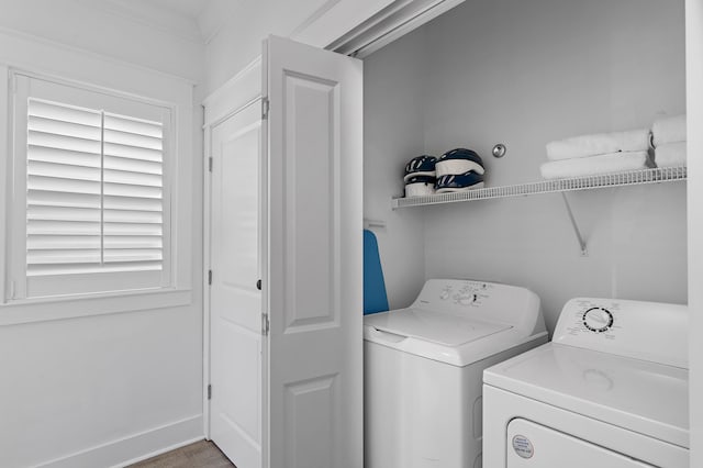 laundry area featuring ornamental molding, light hardwood / wood-style floors, and independent washer and dryer