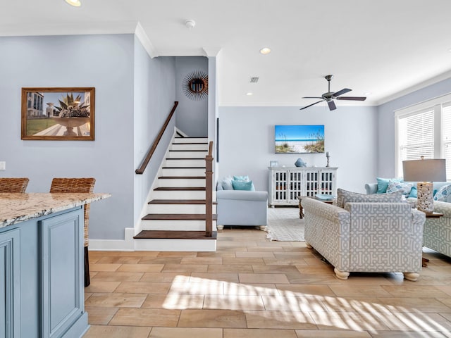 living room featuring ceiling fan and crown molding