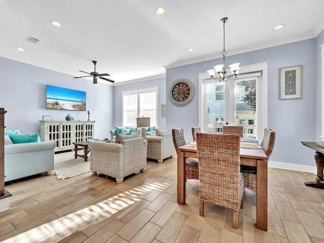 dining area featuring crown molding and ceiling fan with notable chandelier