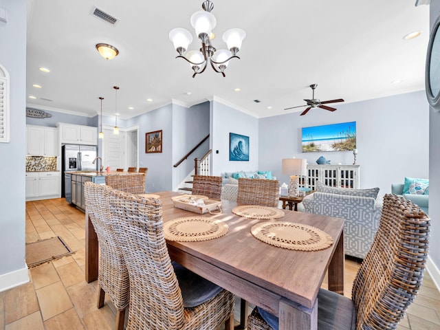 dining space with ceiling fan with notable chandelier and ornamental molding