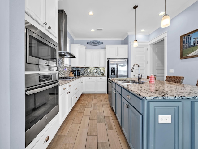 kitchen featuring stainless steel appliances, exhaust hood, backsplash, white cabinets, and sink