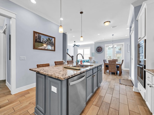 kitchen featuring stainless steel appliances, a center island with sink, gray cabinetry, white cabinetry, and ceiling fan with notable chandelier