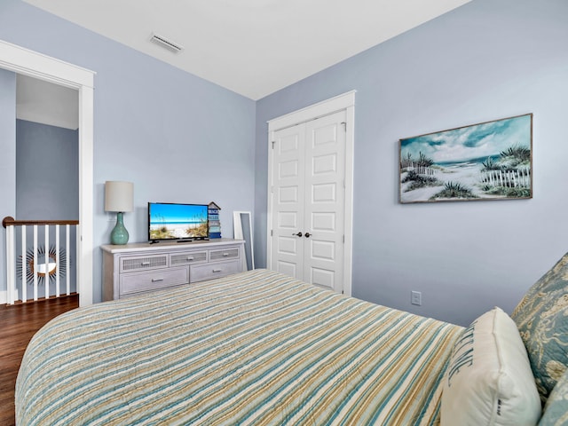 bedroom with a closet and dark hardwood / wood-style flooring