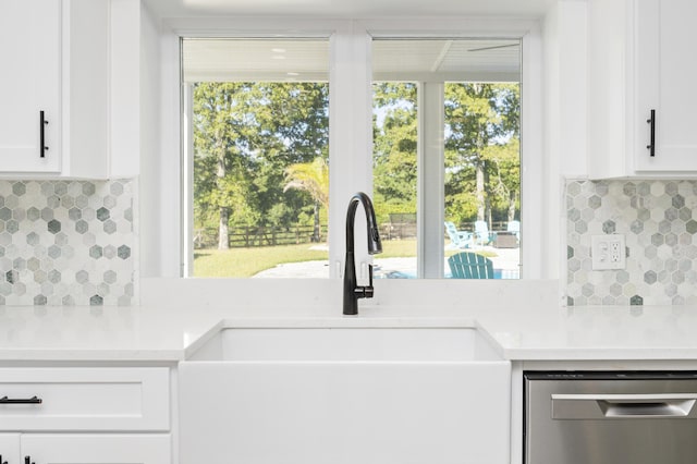 kitchen featuring tasteful backsplash, stainless steel dishwasher, sink, and white cabinets