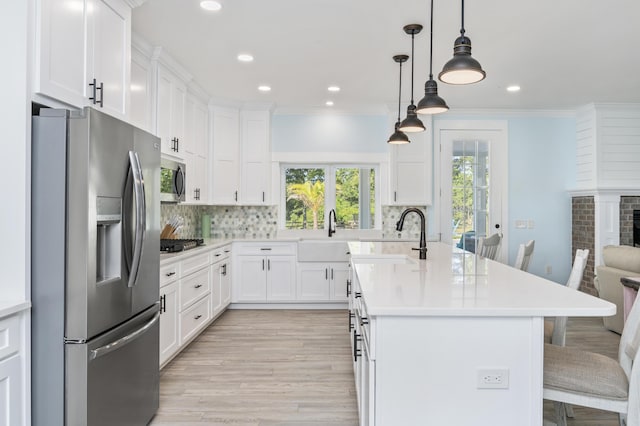 kitchen featuring white cabinetry, stainless steel appliances, and a kitchen breakfast bar