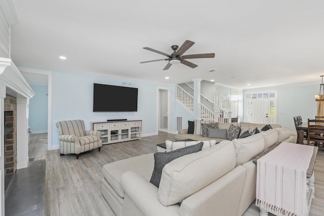 living room featuring ornamental molding, a brick fireplace, ceiling fan, and light hardwood / wood-style floors