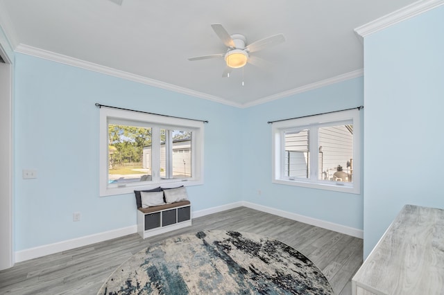 interior space featuring wood-type flooring, ornamental molding, and ceiling fan