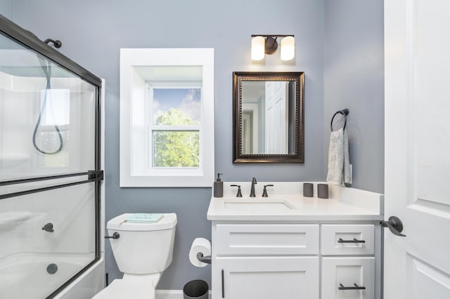 full bathroom featuring toilet, vanity, and bath / shower combo with glass door