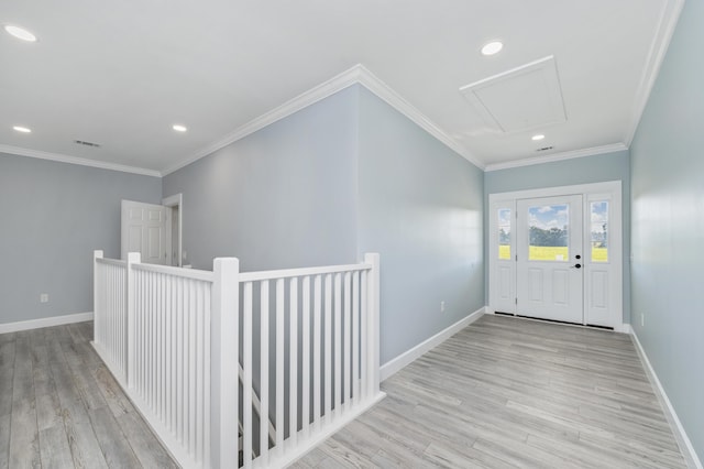 foyer with crown molding and light hardwood / wood-style flooring