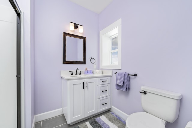 bathroom with tile patterned flooring, vanity, and toilet