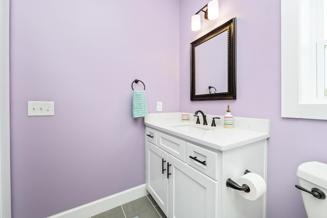 bathroom with tile patterned flooring, vanity, and toilet