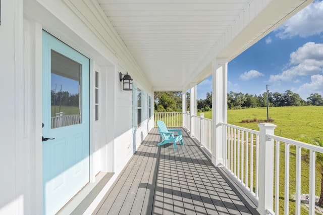 wooden deck with covered porch and a lawn