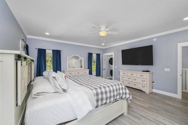 bedroom featuring crown molding, stacked washer and clothes dryer, ceiling fan, and light wood-type flooring