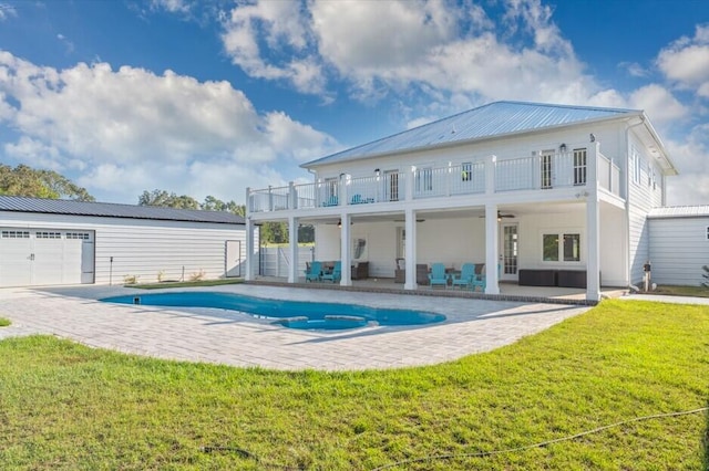 back of property featuring a patio, a balcony, and a lawn