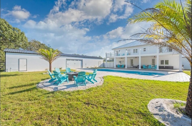 view of yard featuring an outbuilding, a patio area, and a balcony