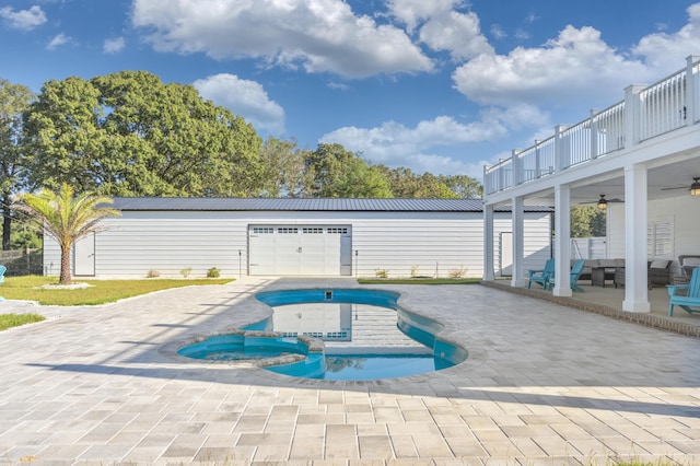 view of swimming pool featuring an in ground hot tub, ceiling fan, a patio, and an outbuilding