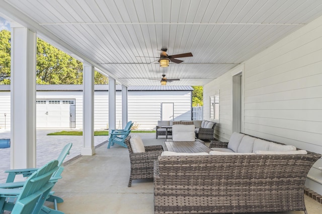 view of patio featuring a garage, outdoor lounge area, and ceiling fan