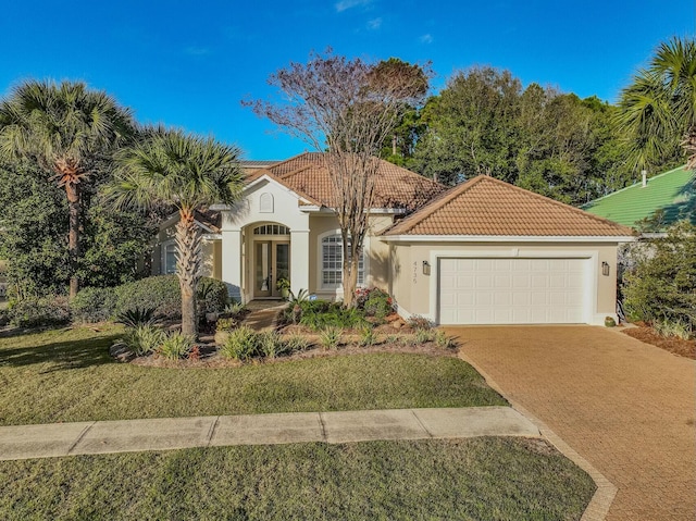 mediterranean / spanish home with a front lawn and a garage