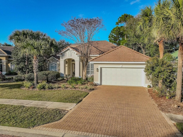 mediterranean / spanish house featuring a front yard and a garage