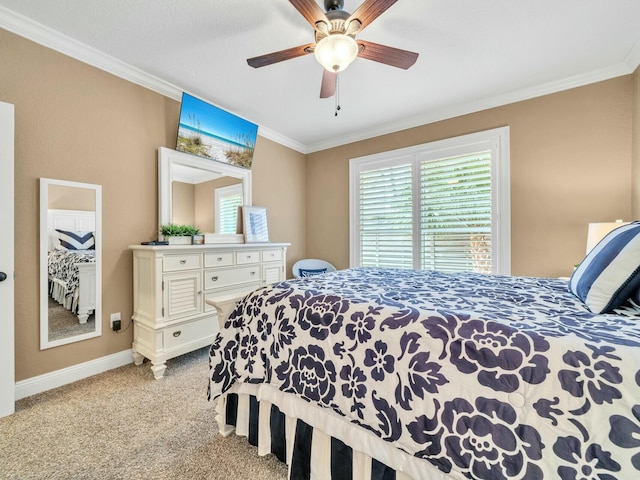 carpeted bedroom featuring ceiling fan and crown molding