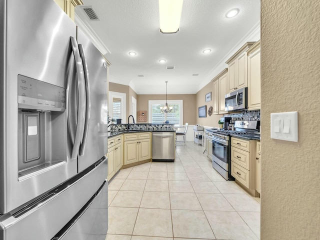 kitchen with sink, ornamental molding, stainless steel appliances, and hanging light fixtures