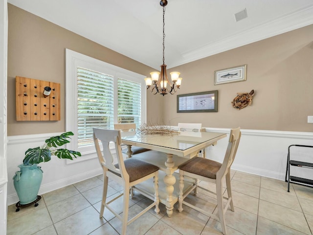 dining area featuring a chandelier, light tile patterned floors, and ornamental molding