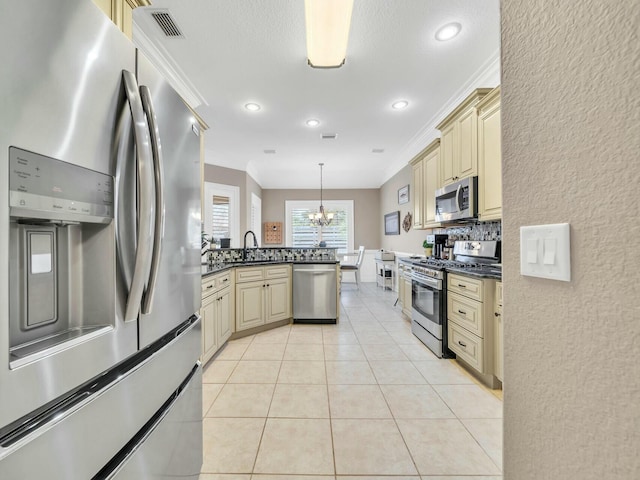 kitchen featuring crown molding, stainless steel appliances, decorative light fixtures, and a notable chandelier