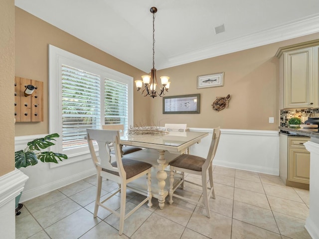 dining space featuring light tile patterned flooring, crown molding, and an inviting chandelier