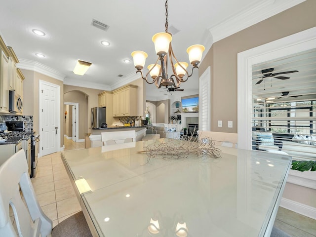 dining area with ceiling fan with notable chandelier, light tile patterned flooring, and ornamental molding