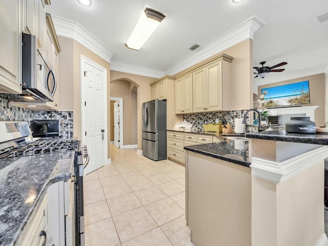 kitchen with backsplash, sink, a textured ceiling, light tile patterned flooring, and stainless steel appliances