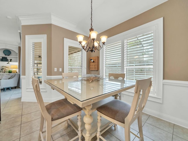 tiled dining area featuring a healthy amount of sunlight, built in features, a notable chandelier, and crown molding