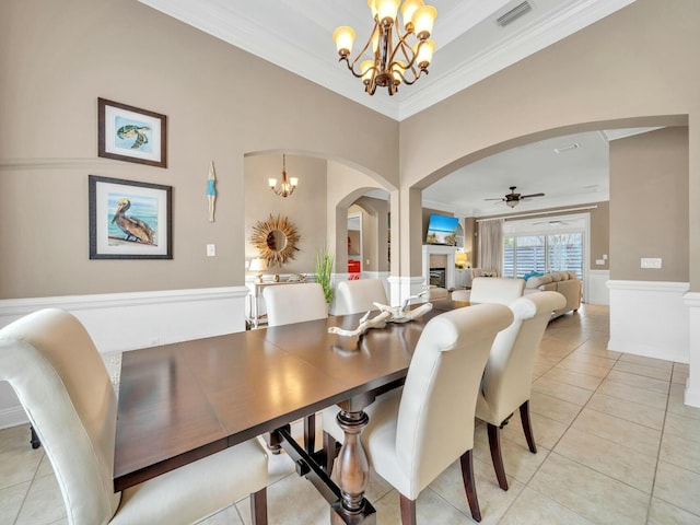 tiled dining space featuring ceiling fan with notable chandelier and ornamental molding