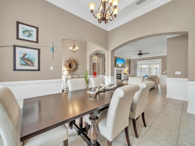 dining area with ceiling fan with notable chandelier, light tile patterned floors, and ornamental molding