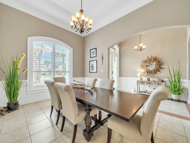 tiled dining space featuring crown molding and an inviting chandelier