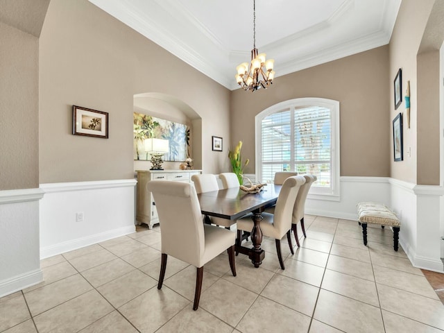 dining area featuring a tray ceiling, crown molding, light tile patterned floors, and a notable chandelier