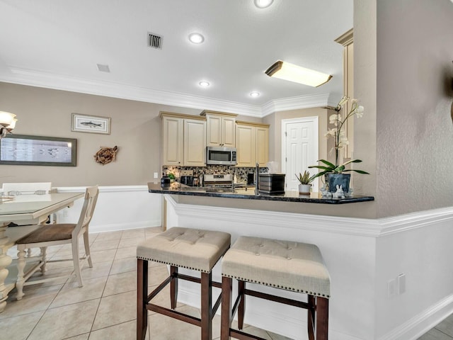 kitchen featuring kitchen peninsula, a kitchen breakfast bar, ornamental molding, light tile patterned floors, and range with electric stovetop