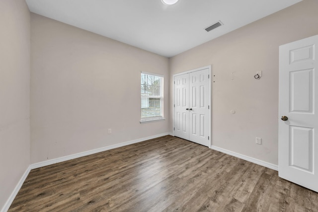 unfurnished bedroom with wood-type flooring and a closet