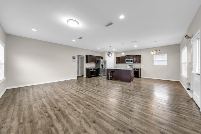 unfurnished living room with a chandelier and dark hardwood / wood-style flooring