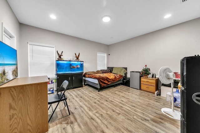 bedroom featuring black refrigerator and light wood-type flooring