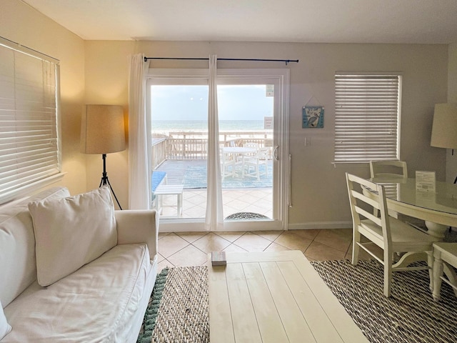 living room with tile patterned floors, a healthy amount of sunlight, and a water view