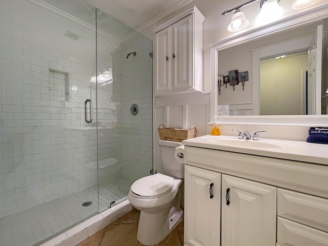 bathroom with tile patterned flooring, vanity, a shower with shower door, and toilet