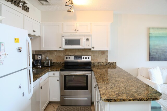 627 Eastern Lake Rd Unit 1, Santa Rosa Beach, FL 32459 - kitchen with white appliances, a peninsula, decorative backsplash, tile patterned flooring, and white cabinetry