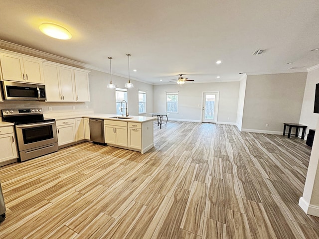 kitchen featuring kitchen peninsula, appliances with stainless steel finishes, ceiling fan, sink, and hanging light fixtures