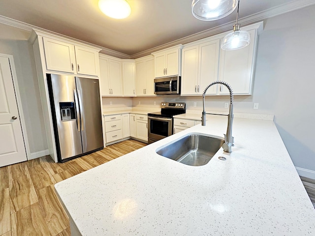 kitchen with white cabinets, stainless steel appliances, hanging light fixtures, and crown molding