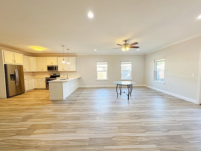 kitchen featuring white cabinetry, stainless steel appliances, kitchen peninsula, plenty of natural light, and pendant lighting